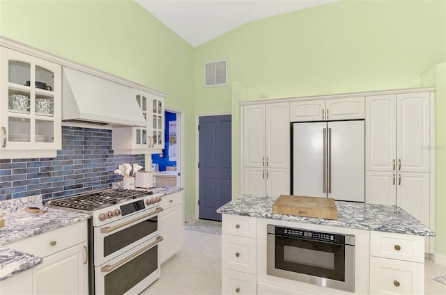 kitchen with white cabinetry, light stone countertops, premium range hood, and premium appliances