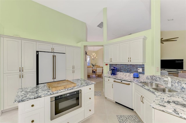 kitchen with built in microwave, high end fridge, light tile patterned floors, dishwasher, and white cabinets