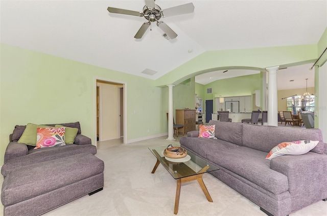 carpeted living room featuring decorative columns, vaulted ceiling, and ceiling fan with notable chandelier