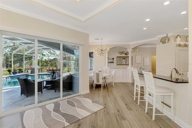 interior space with ornamental molding, decorative columns, and light hardwood / wood-style flooring