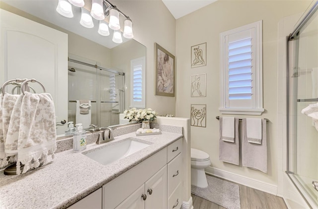 full bathroom with enclosed tub / shower combo, vanity, toilet, and hardwood / wood-style floors