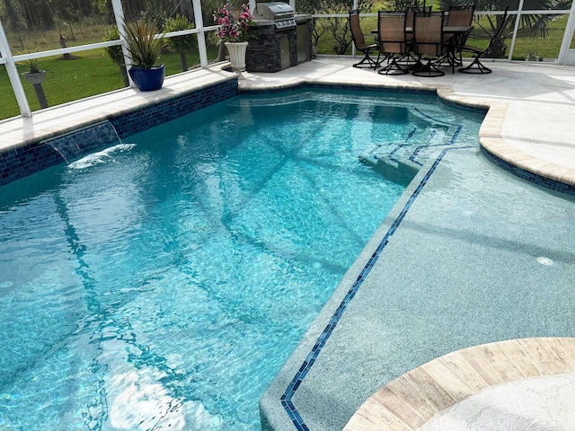 view of pool with a lanai, a grill, and a patio area