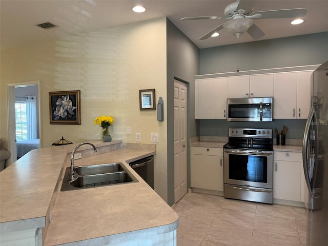 kitchen featuring white cabinetry, appliances with stainless steel finishes, kitchen peninsula, and sink