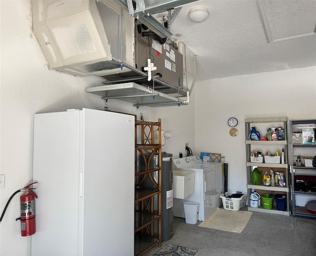 garage with washer and clothes dryer, water heater, and white fridge