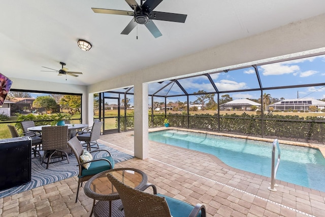 view of swimming pool featuring ceiling fan, glass enclosure, and a patio