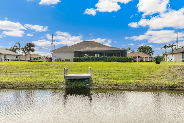 view of dock with a water view, a yard, and glass enclosure