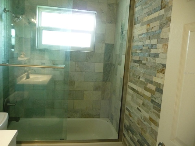 full bathroom featuring bath / shower combo with glass door, vanity, and toilet