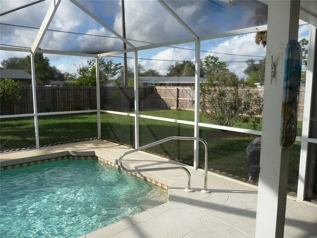 view of pool with a yard, a patio area, and glass enclosure