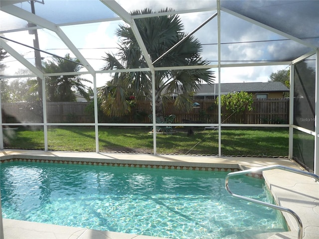 view of swimming pool with a yard and glass enclosure