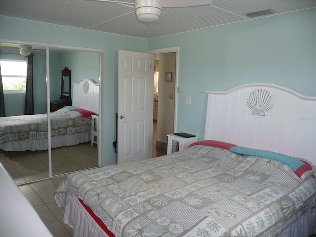 bedroom featuring light tile patterned flooring, ceiling fan, and a closet