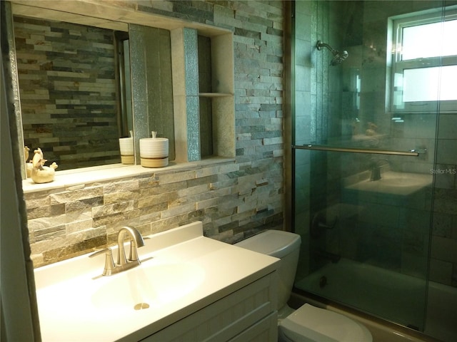 full bathroom featuring enclosed tub / shower combo, toilet, vanity, and decorative backsplash