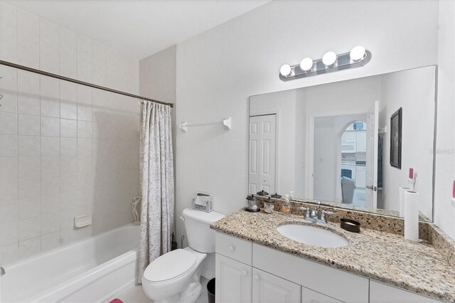 full bathroom featuring vanity, shower / bath combination with curtain, and toilet