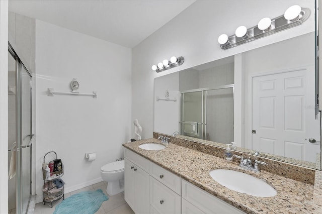 bathroom with tile patterned flooring, vanity, a shower with shower door, and toilet