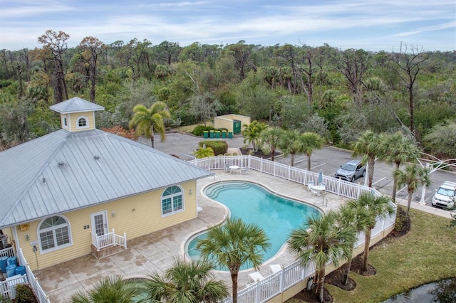 view of swimming pool featuring a shed and a patio area