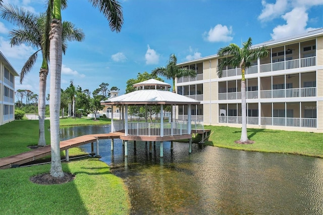 view of dock featuring a water view, a yard, and a gazebo