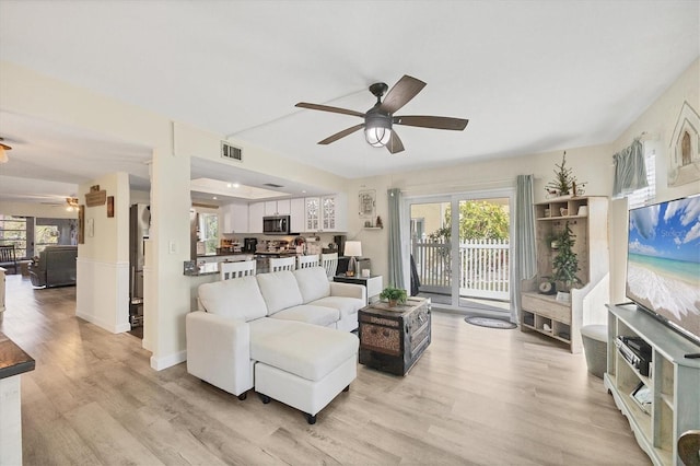 living room featuring ceiling fan and light hardwood / wood-style floors