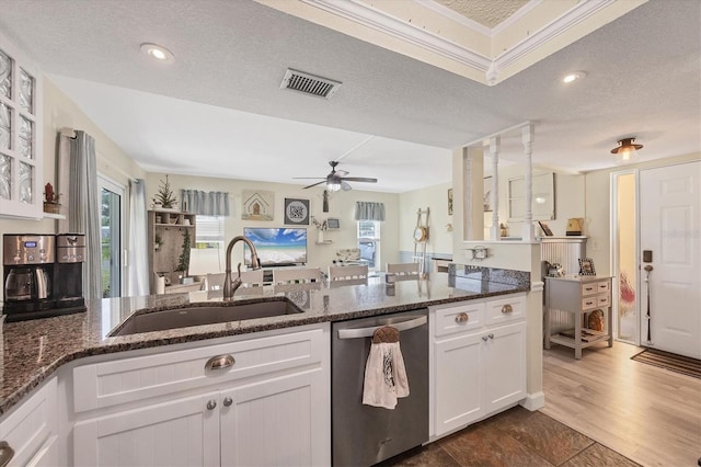 kitchen with sink, a textured ceiling, dark stone countertops, dishwasher, and white cabinets