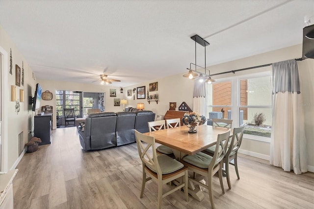 dining area featuring ceiling fan, a textured ceiling, and light hardwood / wood-style floors