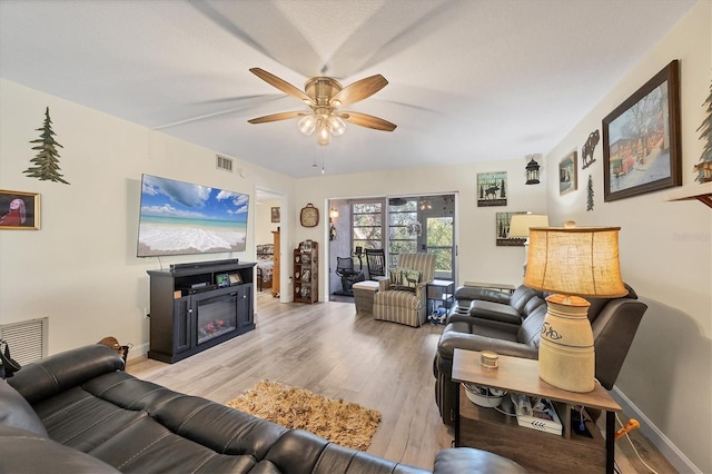 living room featuring ceiling fan and light hardwood / wood-style floors