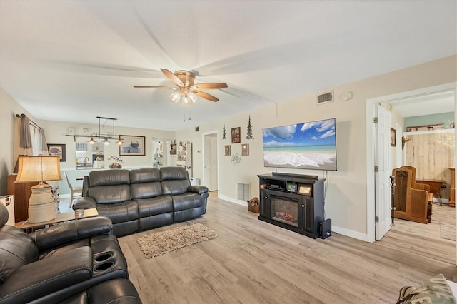 living room with ceiling fan and light hardwood / wood-style floors