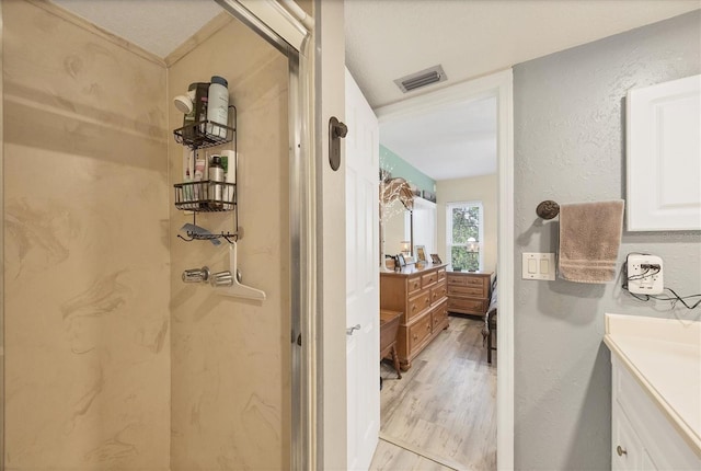 bathroom with vanity, hardwood / wood-style flooring, and a shower