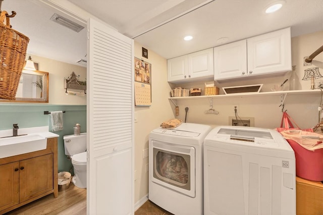 laundry room with sink, light hardwood / wood-style floors, and independent washer and dryer