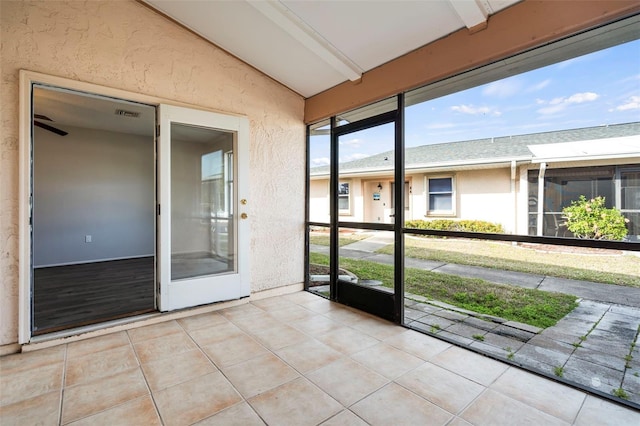 unfurnished sunroom featuring lofted ceiling with beams