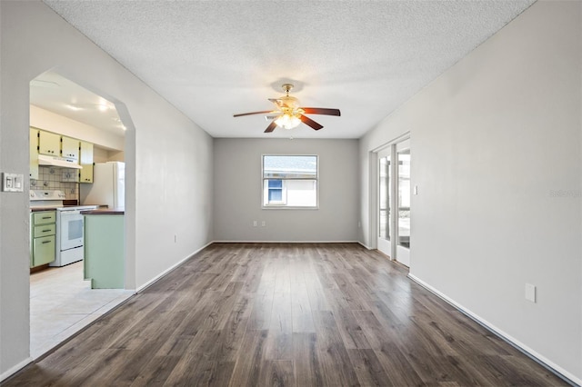 unfurnished room featuring a textured ceiling, light hardwood / wood-style floors, and ceiling fan