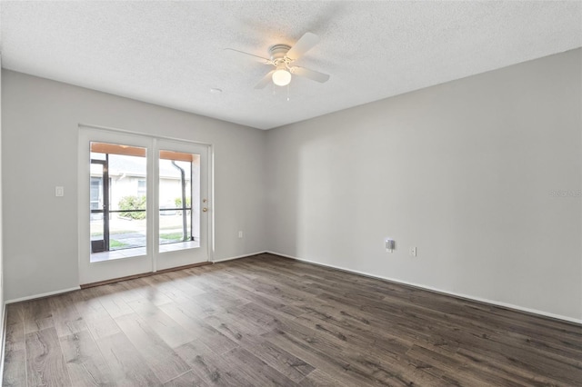 empty room featuring ceiling fan, dark wood-type flooring, and a textured ceiling