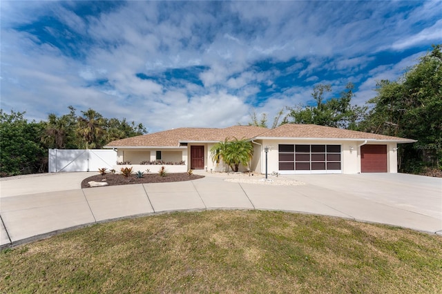 ranch-style home with a garage and a front lawn