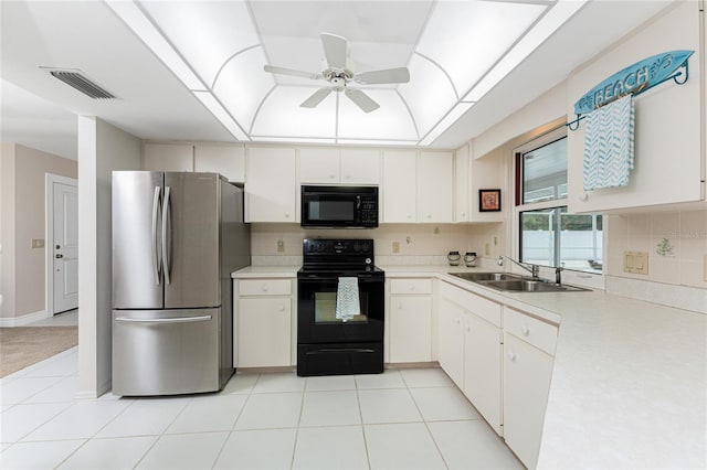 kitchen featuring sink, backsplash, black appliances, white cabinets, and a raised ceiling