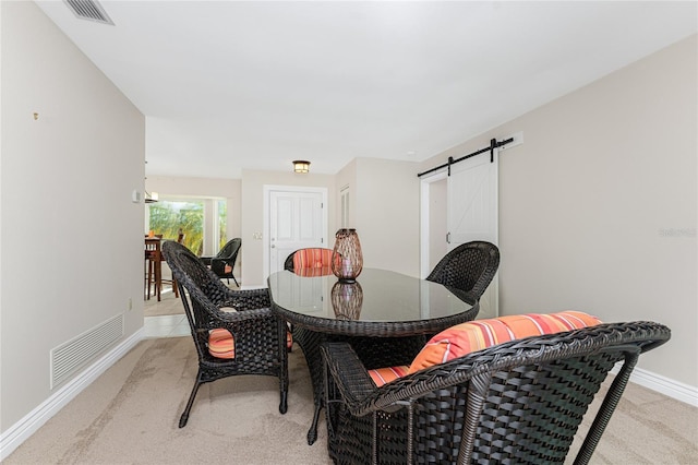 carpeted dining room featuring a barn door