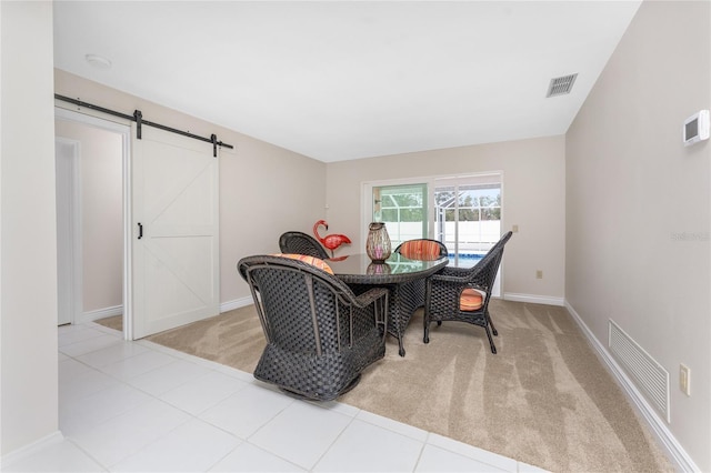 carpeted dining room featuring a barn door