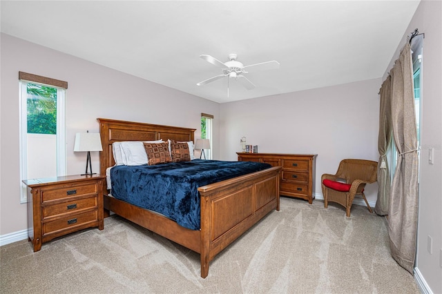 carpeted bedroom with multiple windows and ceiling fan