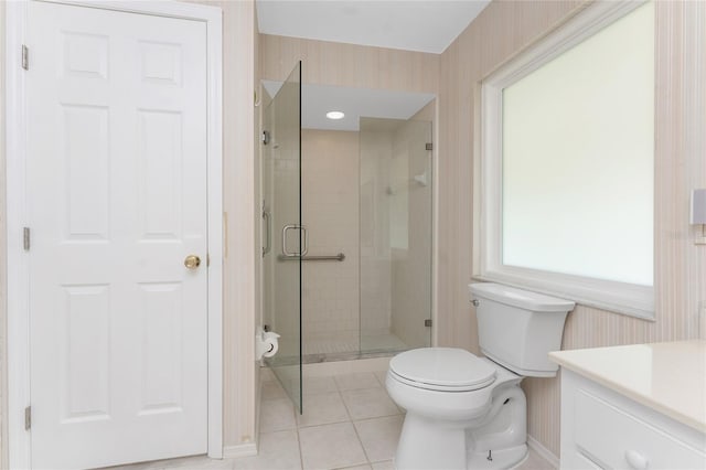 bathroom with tile patterned floors, toilet, a shower with door, and vanity