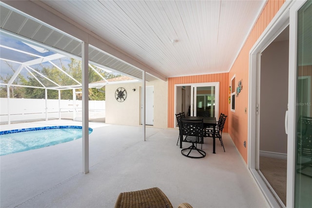 view of swimming pool with glass enclosure and a patio area