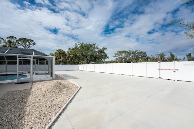 view of patio featuring a fenced in pool and glass enclosure