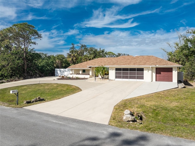 ranch-style house with a garage and a front lawn