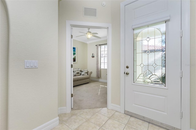 foyer entrance with light colored carpet and ornamental molding