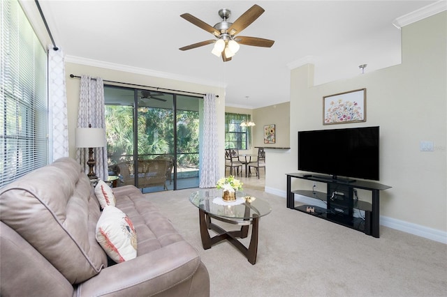 carpeted living room featuring ornamental molding and ceiling fan