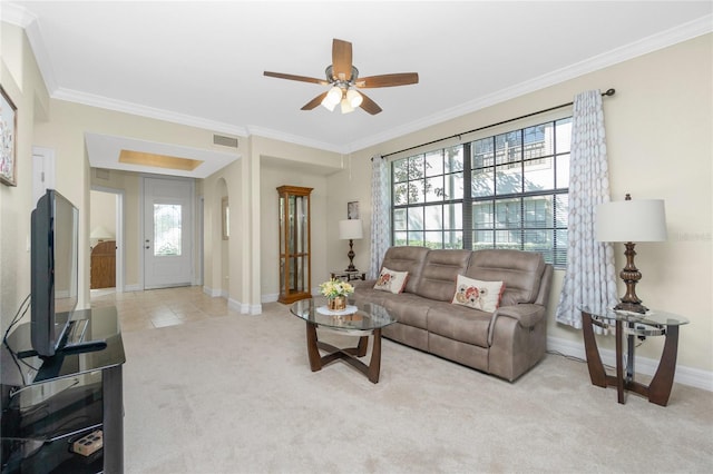 living room with crown molding, ceiling fan, and light carpet