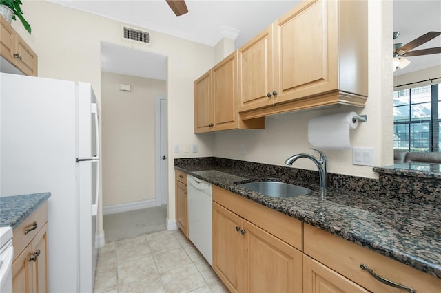 kitchen with ceiling fan, sink, white appliances, and dark stone counters