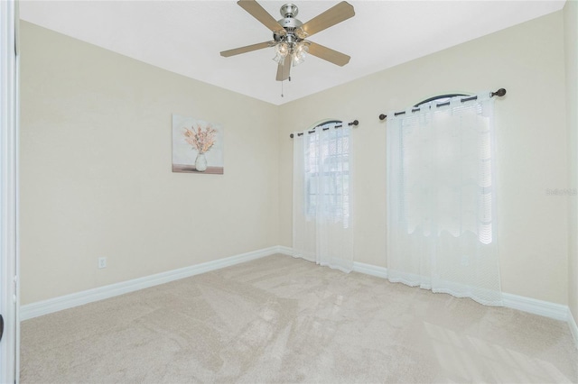 carpeted spare room featuring ceiling fan