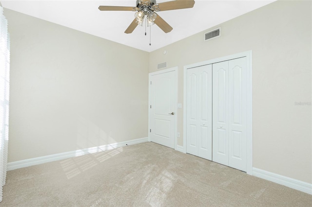 unfurnished bedroom with light colored carpet, ceiling fan, and a closet