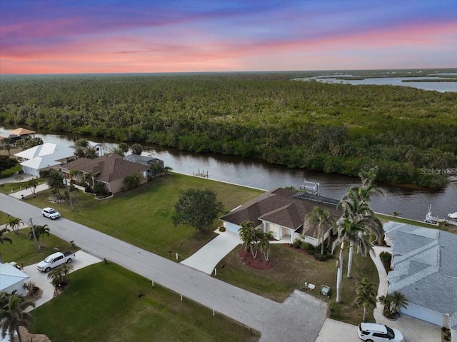 aerial view at dusk featuring a water view