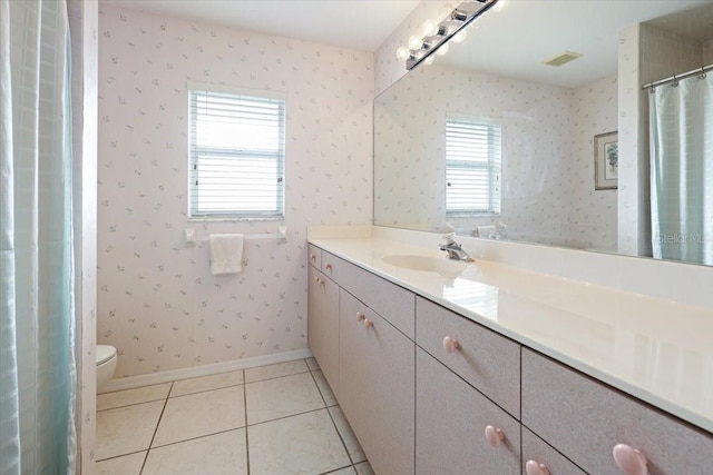 bathroom featuring vanity, baseboards, wallpapered walls, tile patterned floors, and toilet