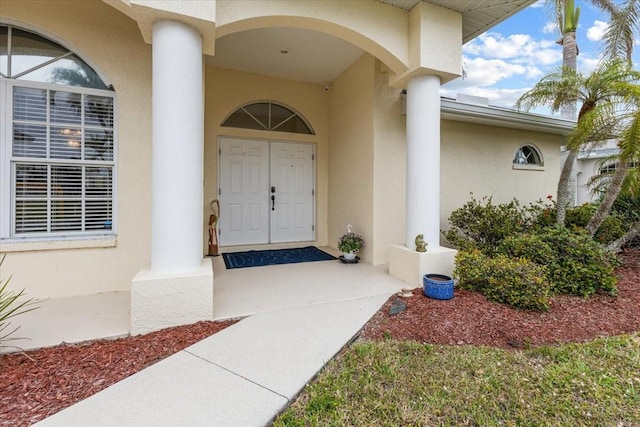 entrance to property featuring stucco siding