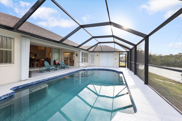 pool featuring glass enclosure and a patio