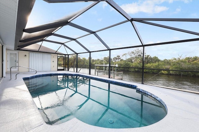 outdoor pool with a lanai, a patio area, and a water view