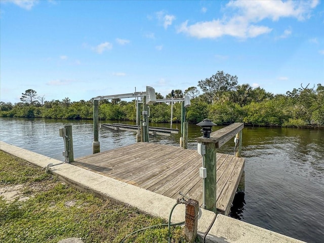 dock area featuring boat lift and a water view